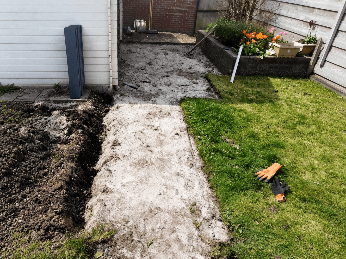 Uitgegraven strook door het gazon als voorbereiding voor het nieuwe looppad.